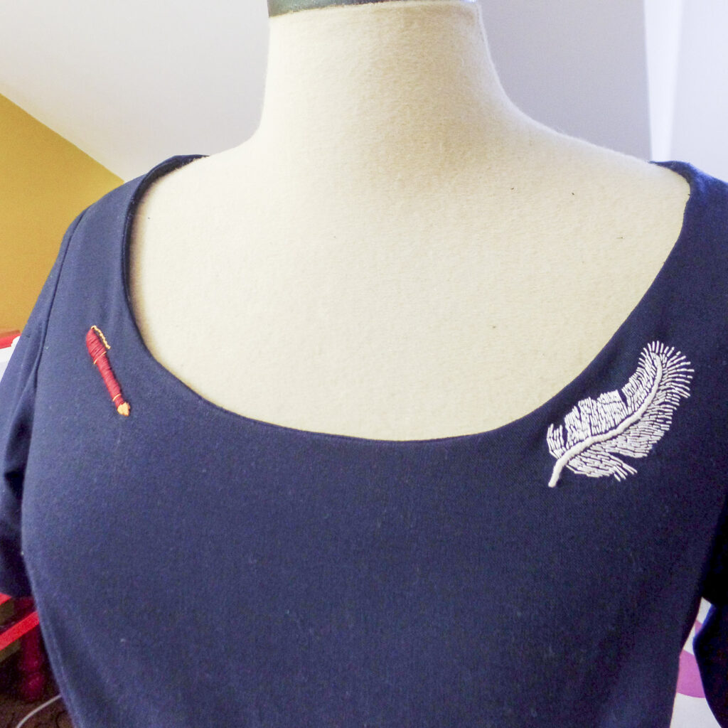 Jurk van Inge na aanpassing bij Curieus Retouches Begijnendijk, met subtiele borduursels van een pluim en een pen als persoonlijke toets.